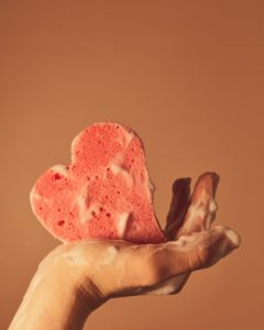 person holding pink heart shaped ornament